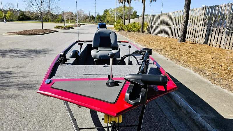 Slide: The Image of 2025 Tracker Panfish 17 boat, red exterior, parked outdoors, featuring seating and fishing equipment. - 8
