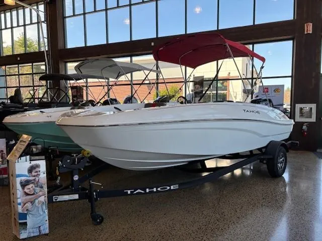 Slide: The Image of 2025 Tahoe T18 boat with red canopy displayed indoors. - 0