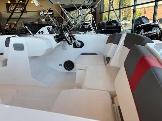 Slide: The Image of 2025 Tahoe T18 boat interior with modern seating and steering wheel, displayed in showroom. - 2