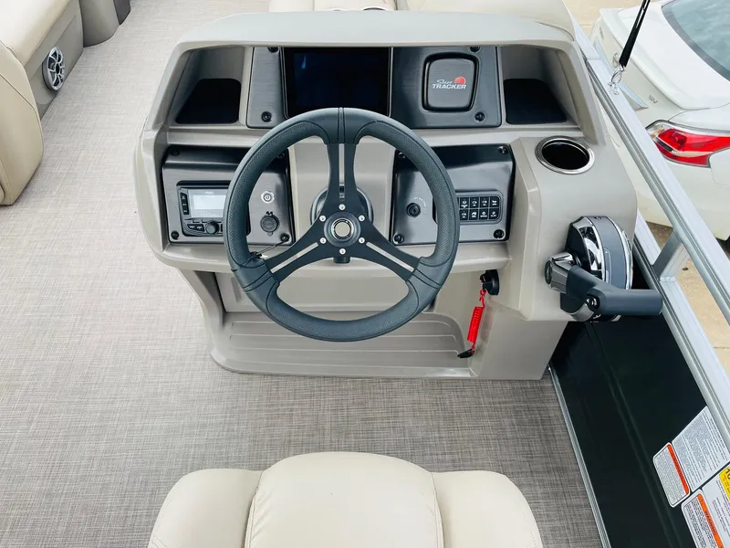 Slide: The Image of 2025 Sun Tracker Party Barge 20 DLX steering console with modern controls and beige interior. - 20
