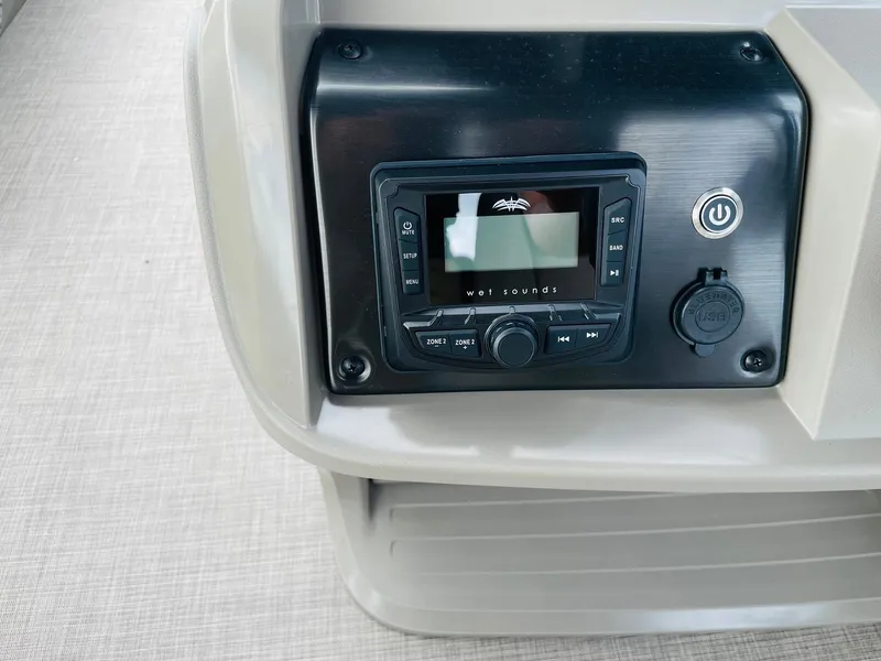 Slide: The Image of 2025 Sun Tracker Party Barge 20 DLX audio control panel on beige interior. - 21
