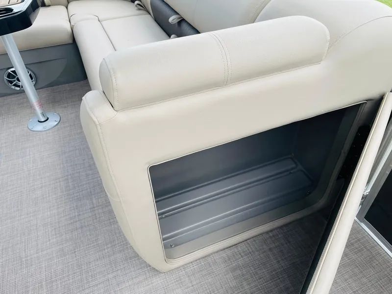 Slide: The Image of 2025 Sun Tracker Party Barge 20 DLX interior storage compartment with beige seating. - 25