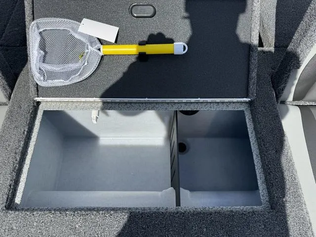 Slide: The Image of 2024 Lund 1775 Impact XS Sport boat storage compartment with net and yellow handle. - 13