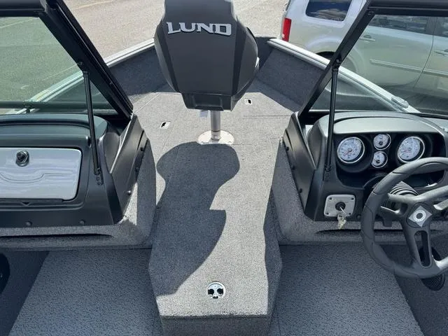 Slide: The Image of 2024 Lund 1775 Impact XS Sport boat interior with steering wheel and dashboard. - 17