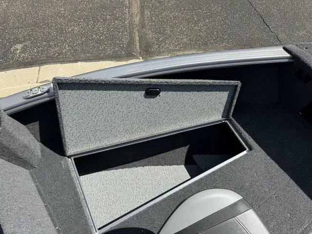 Slide: The Image of 2024 Lund 1775 Impact XS Sport boat storage compartment open, showing interior space. - 20