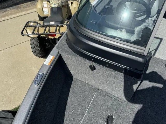 Slide: The Image of 2024 Lund 1775 Impact XS Sport boat interior with windshield and gray carpet. - 23