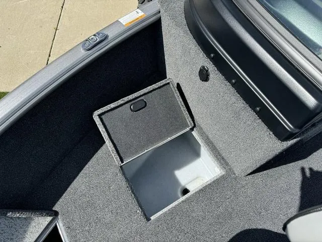 Slide: The Image of 2024 Lund 1775 Impact XS Sport boat storage compartment, open and empty, with gray interior. - 25