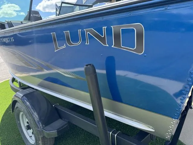 Slide: The Image of 2024 Lund 1775 Impact XS Sport boat, blue exterior, on trailer, sunny day. - 4