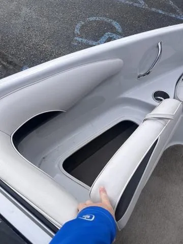 Slide: The Image of 2013 Crownline 18 SS boat interior with white seating and storage compartment. - 12