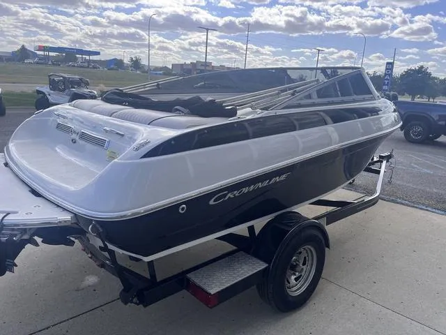 Slide: The Image of 2013 Crownline 18 SS boat on trailer, parked outdoors under a cloudy sky. - 5