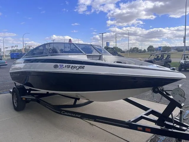 Slide: The Image of 2013 Crownline 18 SS boat on trailer, parked outdoors under a partly cloudy sky. - 6