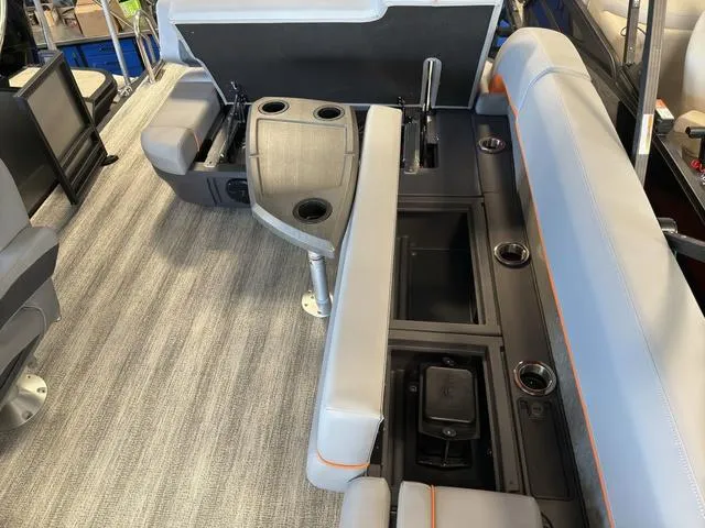 Slide: The Image of 2025 Bennington 22ML Cruise interior with gray seating, cup holders, and storage compartments. - 15