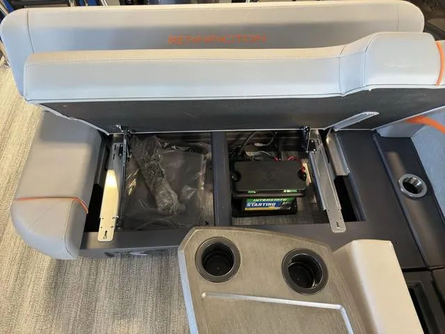 Slide: The Image of 2025 Bennington 22ML Cruise boat interior with open storage compartments and cup holders. - 16