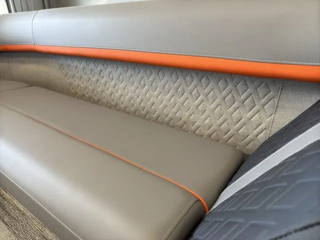 Slide: The Image of Luxurious seating on 2025 Bennington 22ML Cruise with elegant stitching and orange accents. - 17