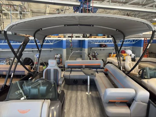 Slide: The Image of 2025 Bennington 22ML Cruise pontoon boat interior with seating and canopy in showroom. - 21