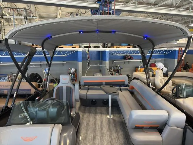 Slide: The Image of 2025 Bennington 22ML Cruise pontoon boat interior with seating and canopy. - 22
