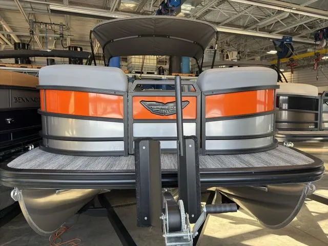 Slide: The Image of 2025 Bennington 22ML Cruise pontoon boat in a showroom, featuring orange and gray accents. - 3