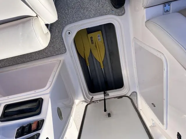 Slide: The Image of 2005 Hurricane FUNDECK202 boat storage compartment with yellow paddles inside. - 16
