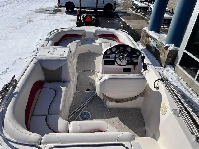 Slide: The Image of 2005 Hurricane FUNDECK202 boat interior with seating and steering console, parked on snowy pavement. - 8
