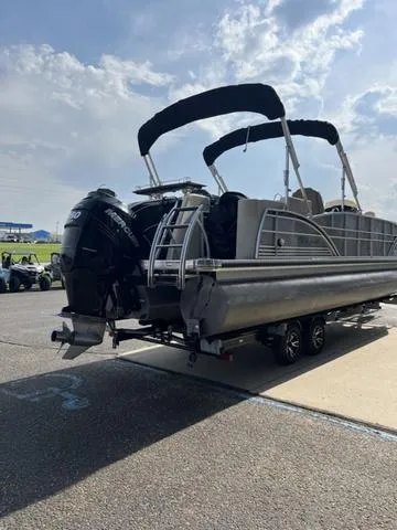 Slide: The Image of 2015 Godfrey 2500 FE BAR pontoon boat on trailer, parked outdoors under a cloudy sky. - 4