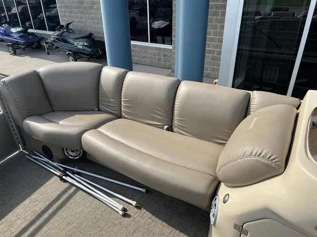 Slide: The Image of Beige seating on 2015 Godfrey 2500 FE BAR boat, with metal rods nearby. - 9