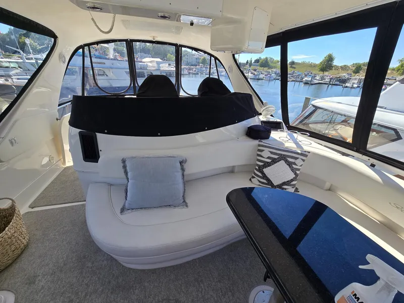 Slide: The Image of Interior of 2002 Sea Ray 560 Sedan Bridge yacht with plush seating and scenic marina view. - 11
