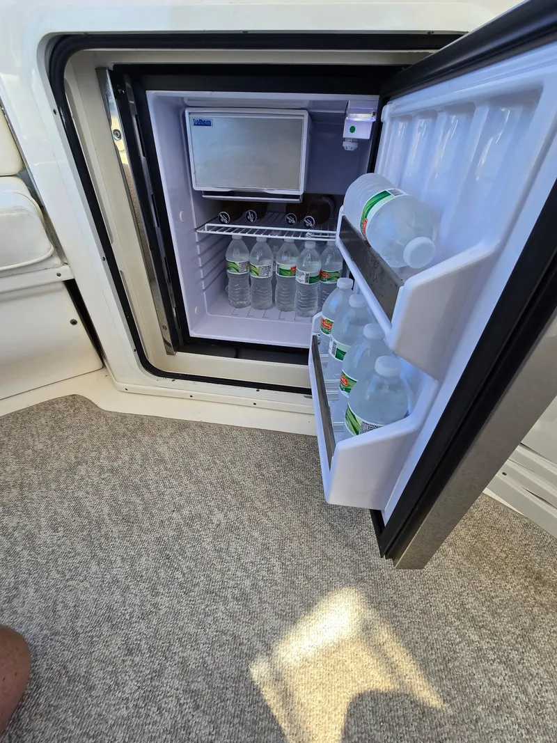 Slide: The Image of Open mini fridge on 2002 Sea Ray 560 Sedan Bridge, stocked with bottled water. - 12