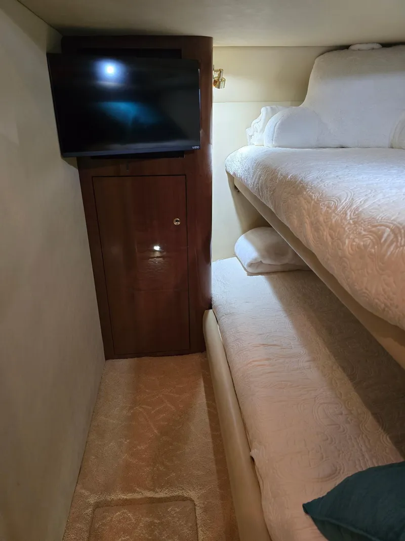 Slide: The Image of 2002 Sea Ray 560 Sedan Bridge cabin with bunk beds and wall-mounted TV. - 18