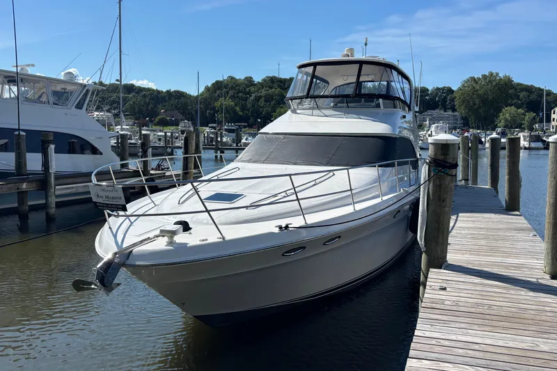 Slide: The Image of 2002 Sea Ray 560 Sedan Bridge yacht docked at a marina on a sunny day. - 2
