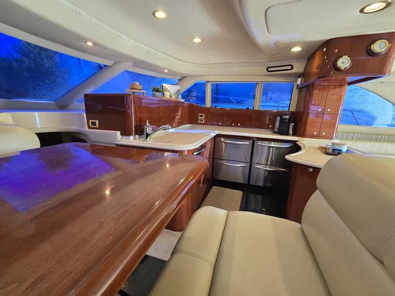 Slide: The Image of Luxurious interior of 2002 Sea Ray 560 Sedan Bridge yacht with elegant wood finishes. - 28