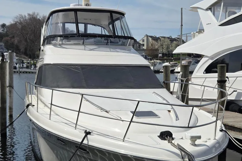Slide: The Image of 2002 Sea Ray 560 Sedan Bridge yacht docked at marina, showcasing sleek design and spacious deck. - 3