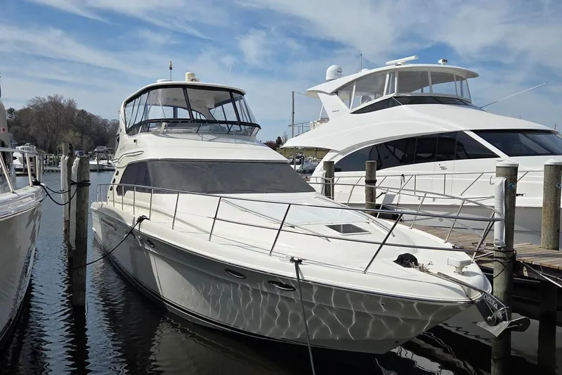 Slide: The Image of 2002 Sea Ray 560 Sedan Bridge yacht docked at marina under blue sky. - 4