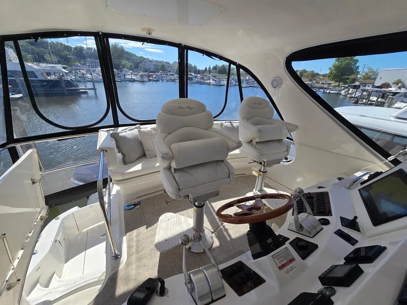 Slide: The Image of Luxurious 2002 Sea Ray 560 Sedan Bridge interior with helm and plush seating. - 8