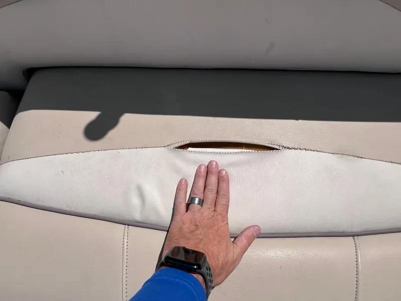 Slide: The Image of Hand touching worn seat on 2017 NauticStar 203SC Sport Deck boat. - 12