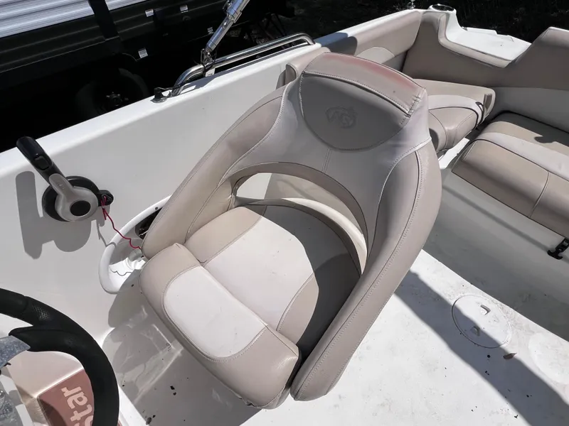 Slide: The Image of 2017 NauticStar 203SC Sport Deck boat interior with beige seating and steering wheel. - 15