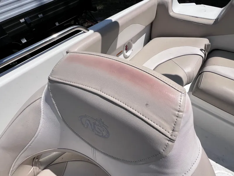 Slide: The Image of 2017 NauticStar 203SC Sport Deck boat interior with beige seating and slight discoloration. - 16