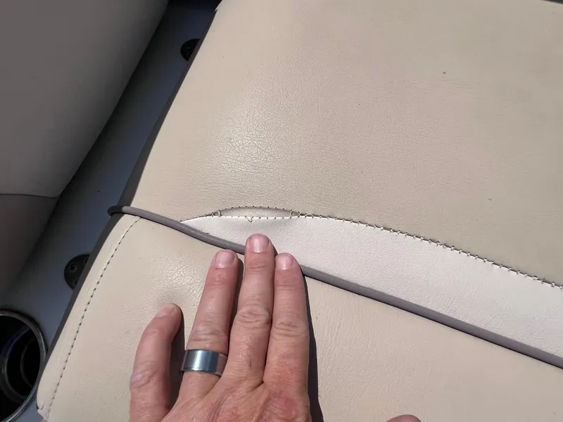Slide: The Image of Hand touching beige seat upholstery on 2017 NauticStar 203SC Sport Deck boat. - 22