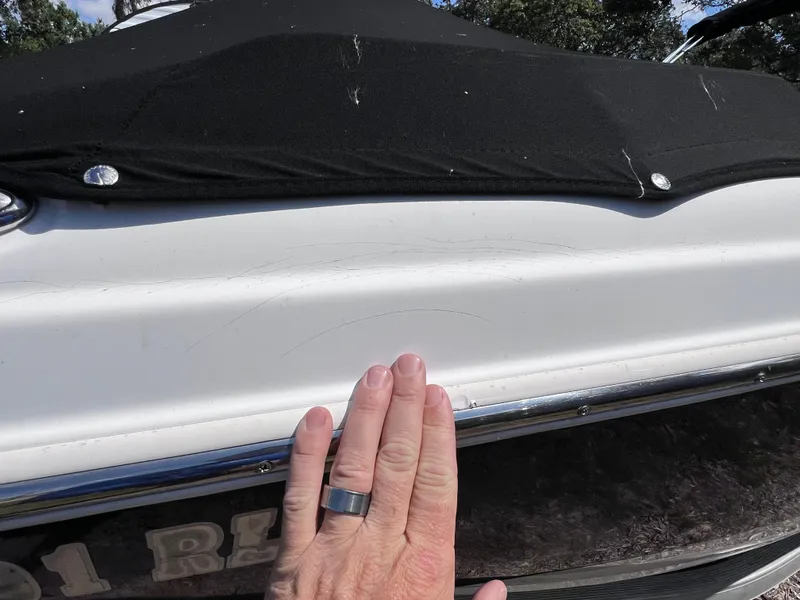 Slide: The Image of Hand touching 2017 NauticStar 203SC Sport Deck boat with black cover. - 5