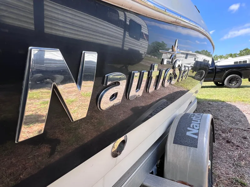 Slide: The Image of 2017 NauticStar 203SC Sport Deck boat with logo, parked outdoors. - 6