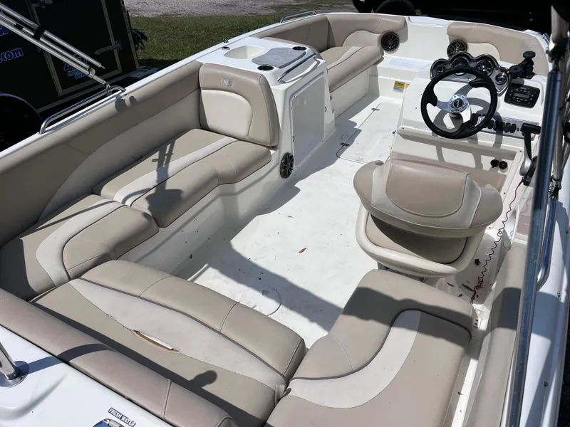 Slide: The Image of 2017 NauticStar 203SC Sport Deck boat interior with beige seating and steering console. - 8