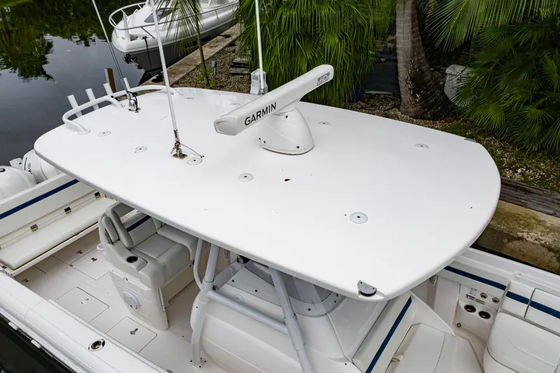 Slide: The Image of 2018 Intrepid 327 Center Console boat with Garmin radar, docked near palm trees. - 11