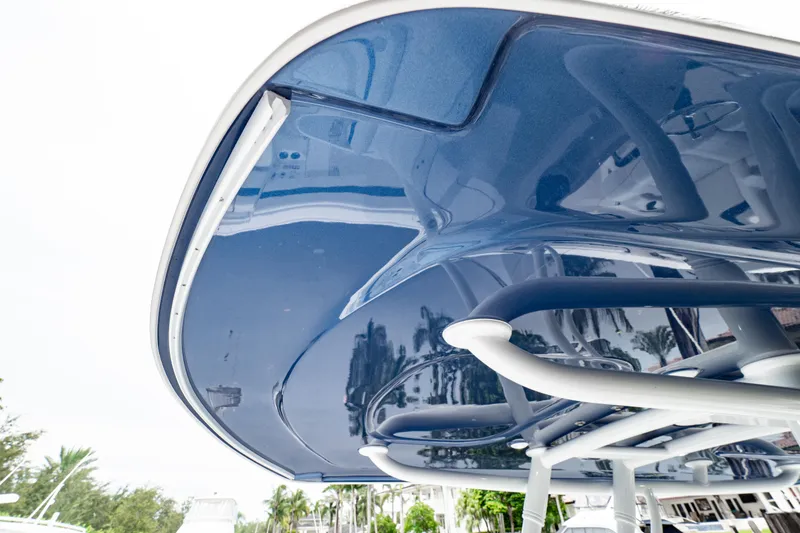 Slide: The Image of 2018 Intrepid 327 Center Console boat, blue hull, sleek design, docked outdoors. - 19