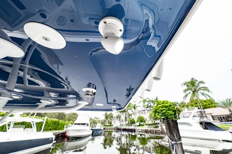 Slide: The Image of 2018 Intrepid 327 Center Console boat docked, reflecting on calm water with surrounding yachts. - 20