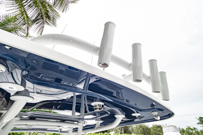 Slide: The Image of 2018 Intrepid 327 Center Console boat with rod holders and sleek design under palm trees. - 22