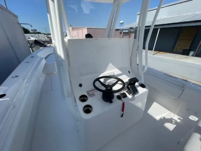 Slide: The Image of 2025 Contender 35 ST boat cockpit with steering wheel and controls, docked under clear sky. - 13