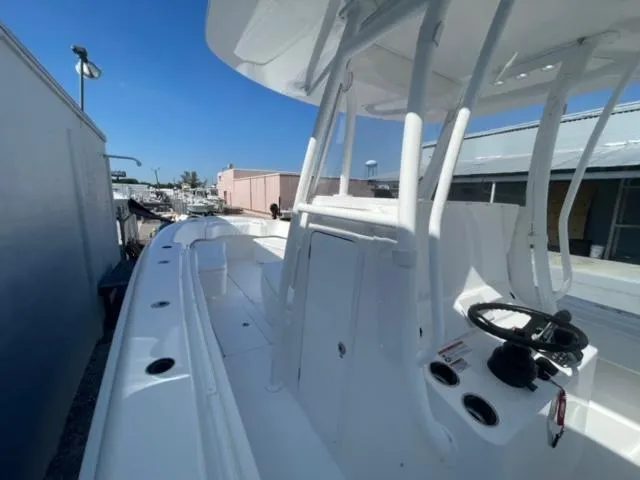 Slide: The Image of 2025 Contender 35 ST boat, sleek white design, docked under clear blue sky. - 17