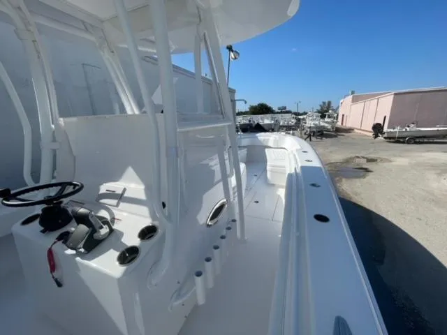 Slide: The Image of 2025 Contender 35 ST boat, sleek white design, spacious deck, modern controls, outdoor setting. - 18