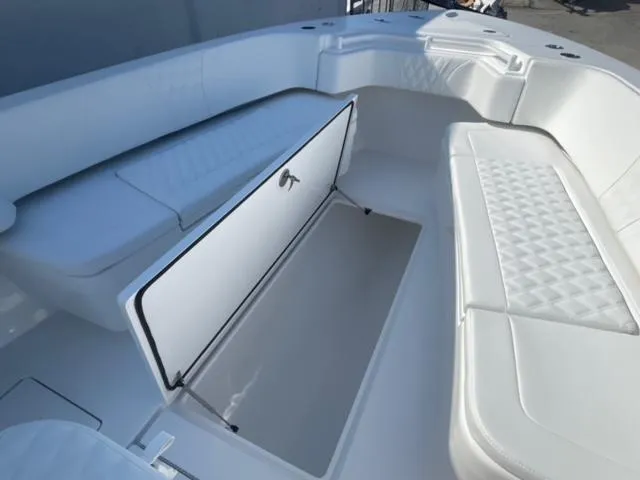 Slide: The Image of 2025 Contender 35 ST boat interior with open storage compartment and cushioned seating. - 24