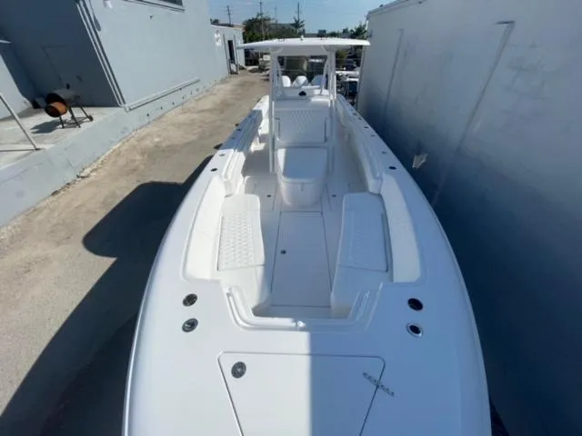 Slide: The Image of 2025 Contender 35 ST boat, sleek white design, docked in narrow alleyway. - 28