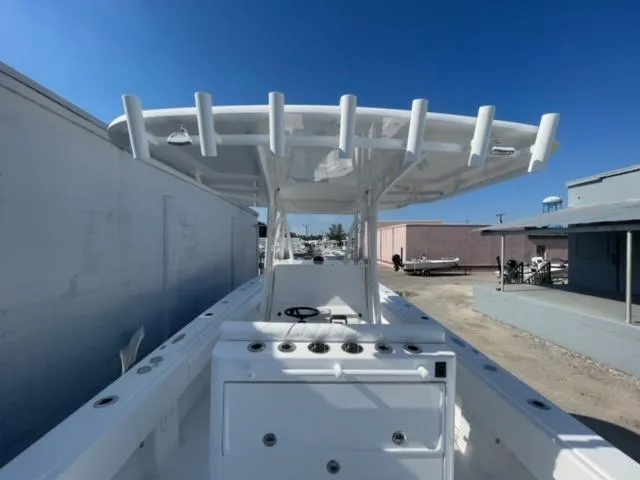 Slide: The Image of 2025 Contender 35 ST boat with T-top, docked under clear blue sky. - 33